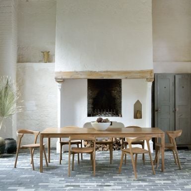 solid teak extendable dining table with matching chairs and a modern design 